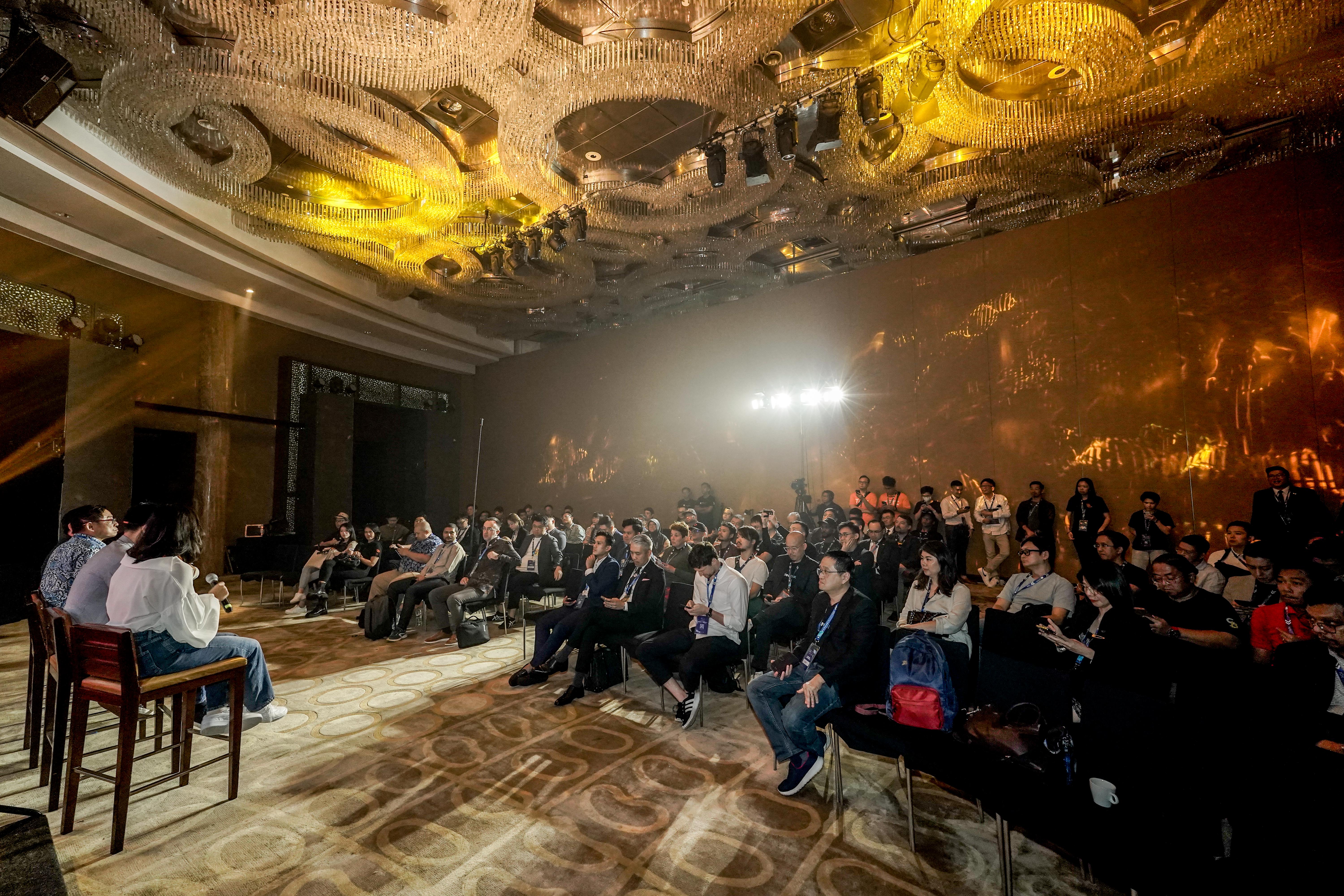 A packed ballroom audience at an evening Bitcoin fireside session